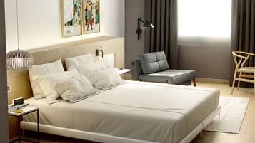 A modern hotel room with a large bed, a bedside table with a lamp, a chair, and artwork on the wall.