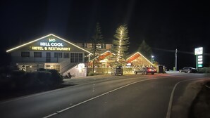 Un hotel llamado "Hill Cool" con un cartel que indica que ofrece un restaurante.