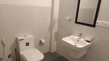 A bathroom with a toilet, sink, and mirror.
