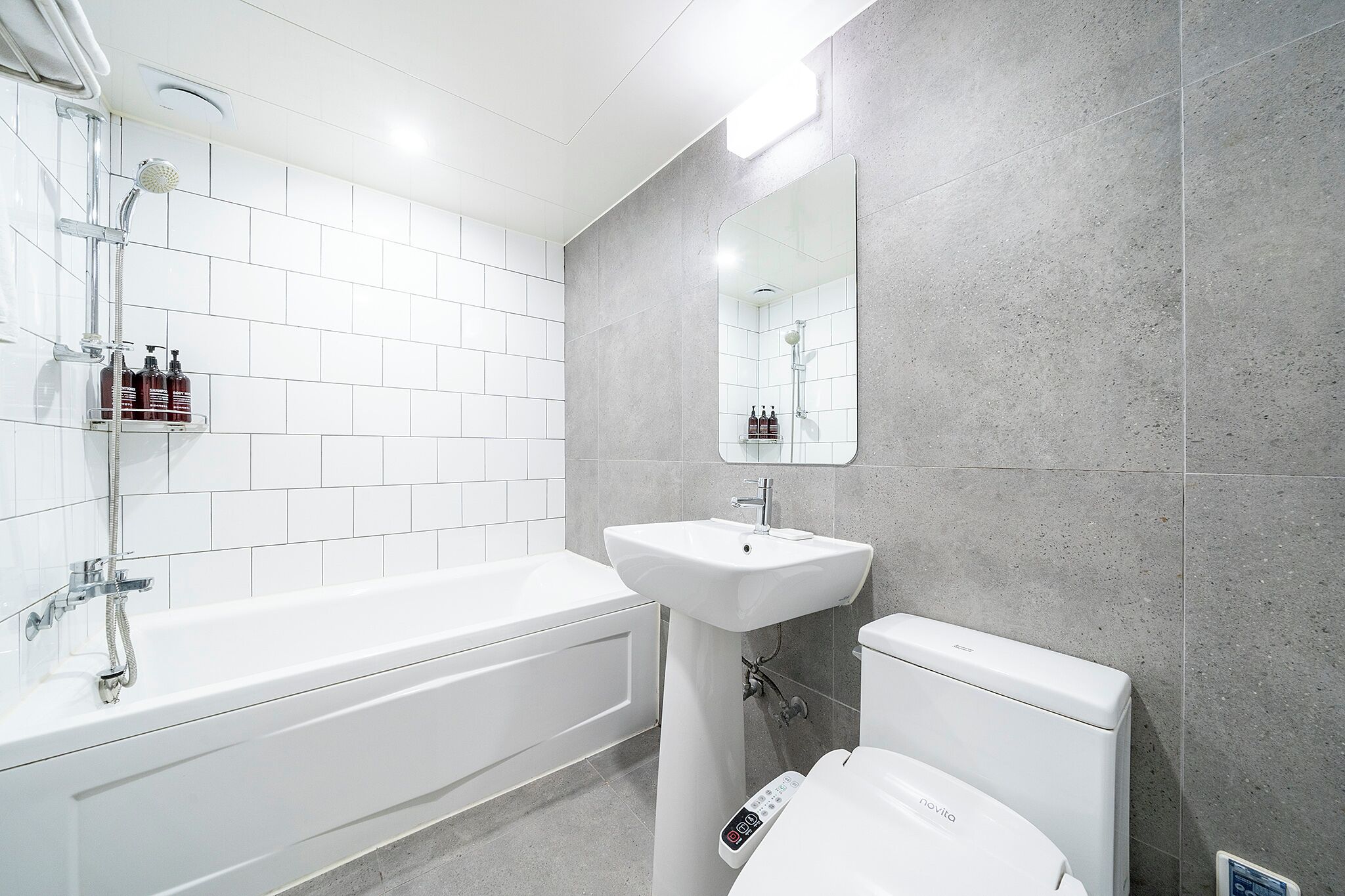 A modern bathroom with a bathtub, a sink, and a toilet.