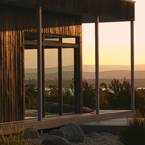 A modern building with large windows and a view of the landscape.