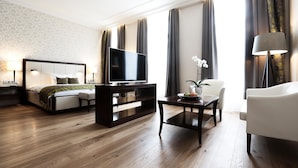 Ein modernes Hotelzimmer mit Bett, Fernseher, Schreibtisch und Stuhl.
