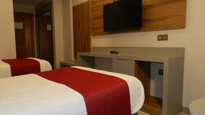 A hotel room with two beds, a desk, a flat-screen TV, and a wooden accent wall. - Konuk Hotel (Gerede)