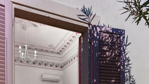 A room with a bed, a dresser, a mirror, and a chandelier. - Villino Ermione (Pisa)