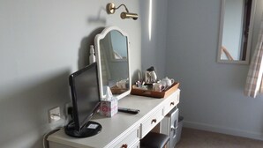 A bedroom with a bed, a desk with a computer, a chair, and a dresser. - Fairways Lodge B&B (Isle of Mull)