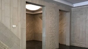 A spacious interior with dark marble flooring, concrete walls with textured patterns, and a recessed ceiling light. - Nice view Apartment (Chnaneir)