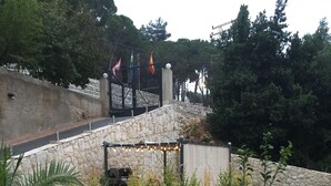 A garden with a stone wall, potted plants, and a grassy lawn. - Nice view Apartment (Chnaneir)