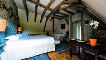 A bedroom with a bed, wooden beams, a brick wall, and a window.