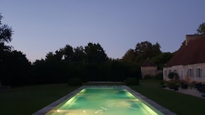 A rectangular swimming pool with a tiled edge, surrounded by a grassy lawn and trees. - Château de Saint Georges (Saint-Georges-sur-Moulon)