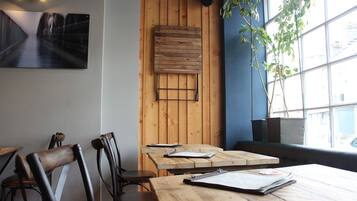 A restaurant interior with wooden walls, a large window, and a table with menus.