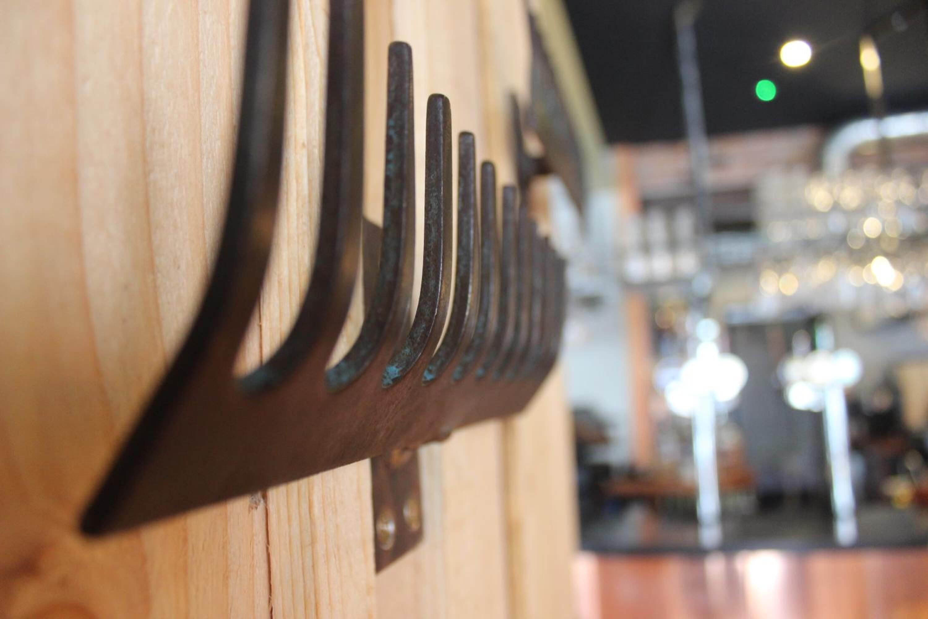 A close-up of a wooden wall with a metal rack holding several black objects.