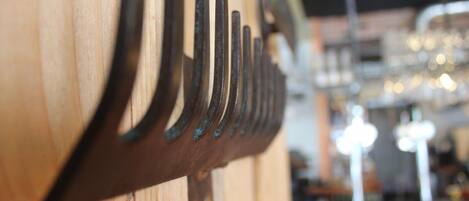 A close-up of a wooden wall with a metal rack holding several black objects.
