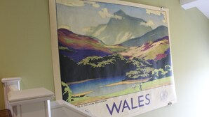 A poster of a scenic landscape with mountains and a lake, labeled "WALES". - The Tilman (Barmouth)