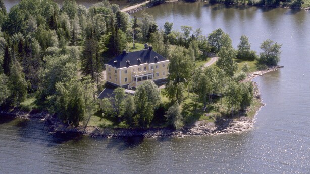 Een afgelegen huis, omringd door dicht bos en een meer.