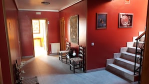 A hallway with a staircase, a radiator, and a door leading to another room.