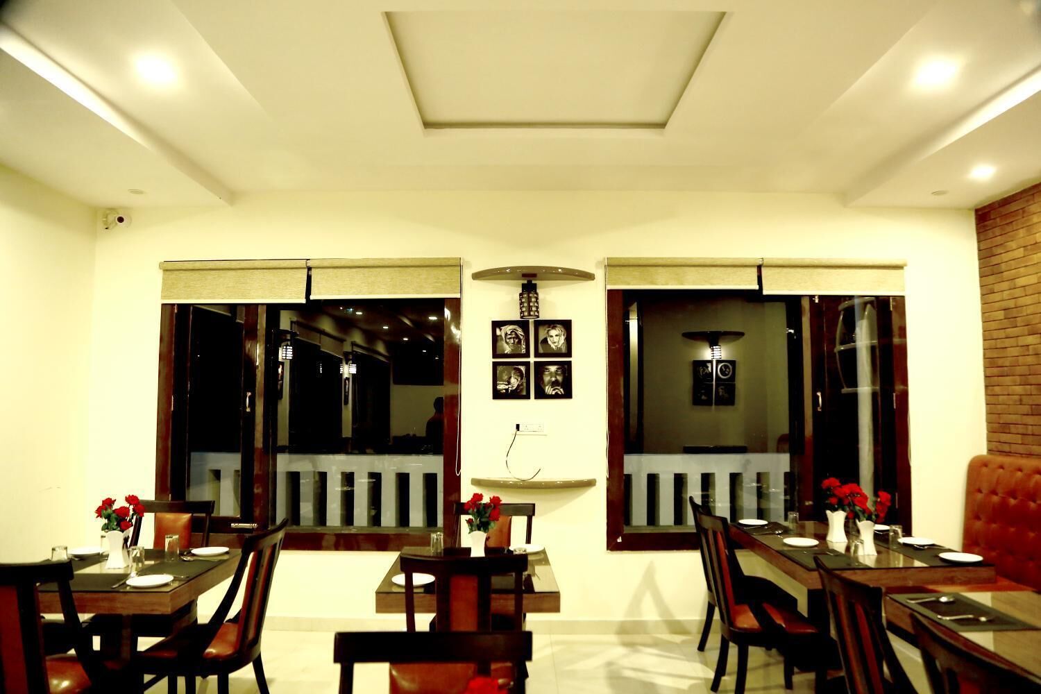 A dining area with two long tables, chairs, and a red upholstered sofa.