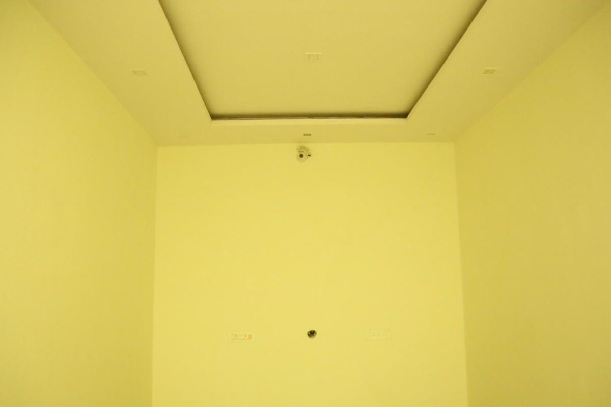 Una habitación con una pared amarilla lisa y un techo sencillo.
