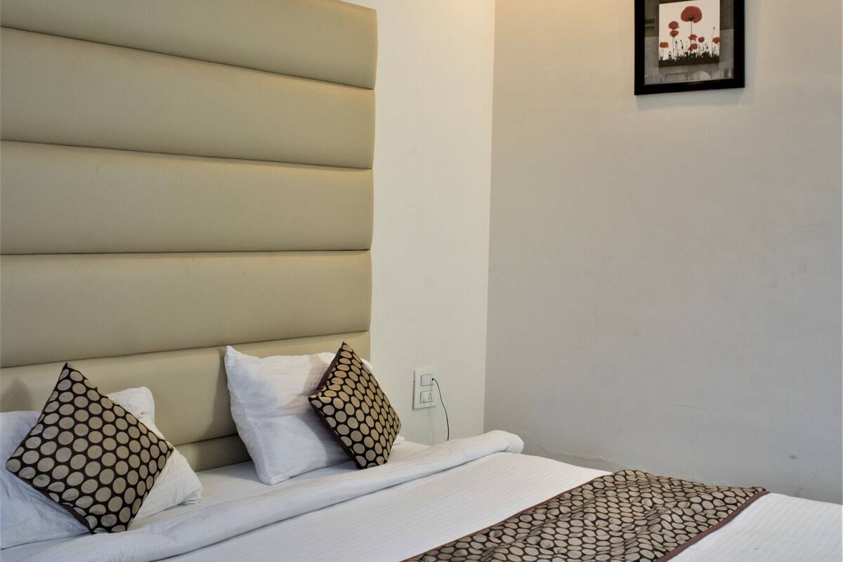 A neatly made bed with a patterned bedspread, a headboard, and a ceiling fan.