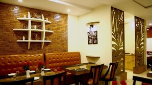 Un restaurante con pared de ladrillo, banco de madera y mesa con sillas.