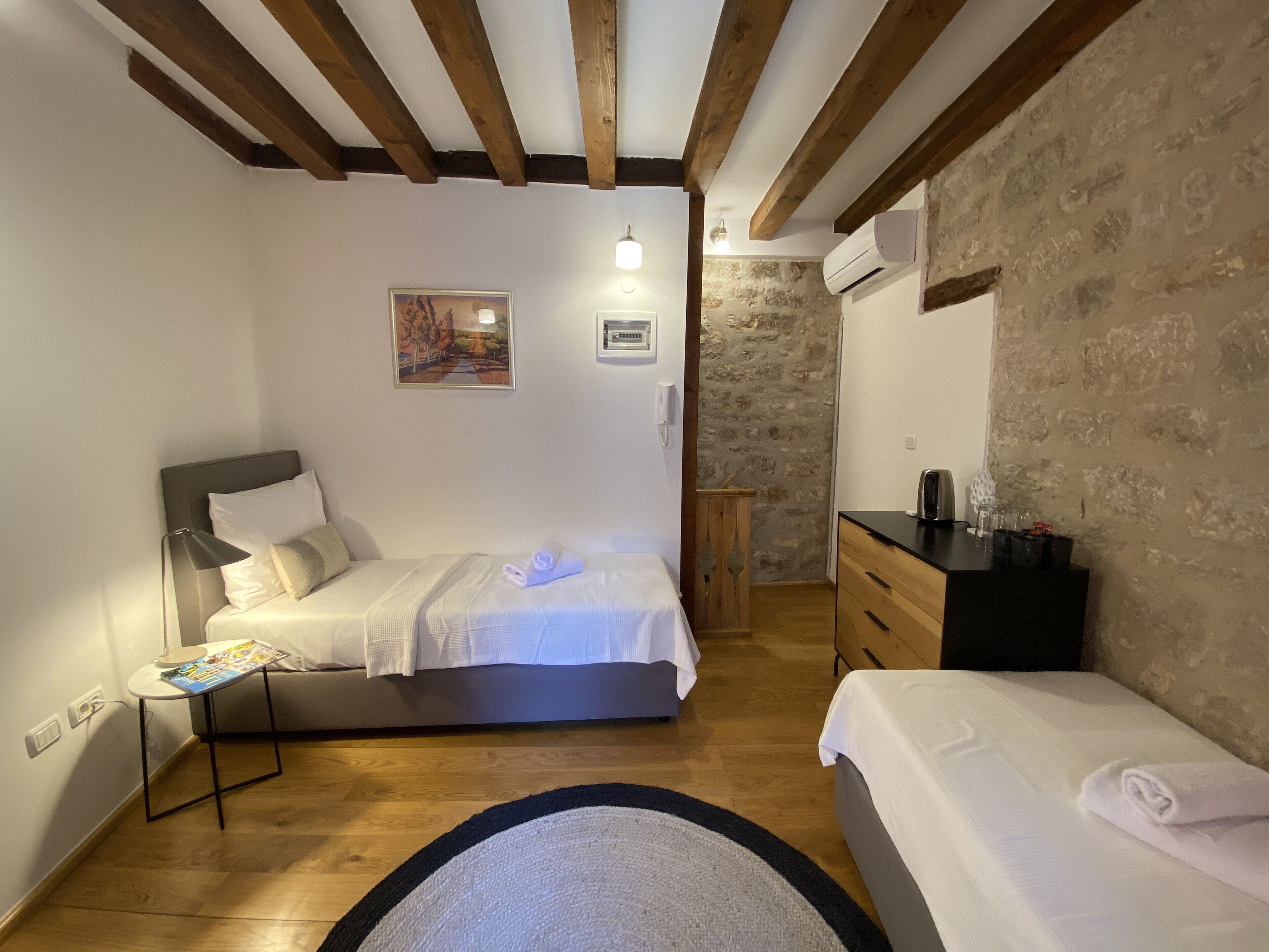 Un dormitorio con una cama, mesita de noche y cómoda.