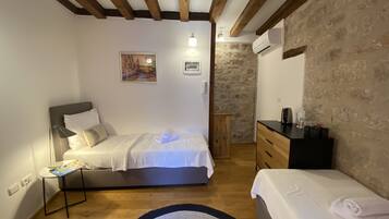 Un dormitorio con una cama, mesita de noche y cómoda.