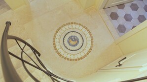 A spiral staircase with a decorative mosaic floor. - Noemi's rooms (Rovinj)