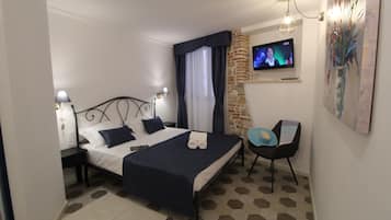 Een slaapkamer met een bed, een stoel, een televisie en een schilderij.