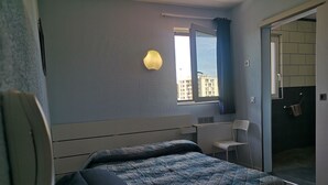 A bedroom with a bed, a desk, and a chair. - Hotel Triotel (La Valette-du-Var)
