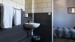 A modern bathroom with a sink, mirror, and towel rack. - Hotel Triotel (La Valette-du-Var)