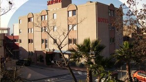 A hotel building with a flat facade, multiple windows, and a sign that reads "HOTEL" on the side. - Hotel Triotel (La Valette-du-Var)