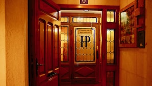 A hotel entrance with a sign reading "Estamos en el bar del hotel" and a prominent 'HP' logo. - Hotel Plaza (Riaza)