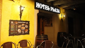 A restaurant named "Hotel Plaza" with a menu board, wicker chairs, and barrels. - Hotel Plaza (Riaza)