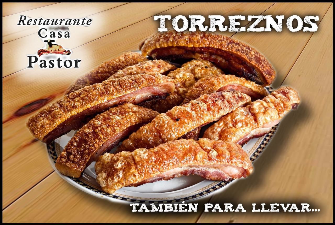 Un plato de panceta de cerdo asada, también conocida como 'torreños', sobre una mesa de madera.