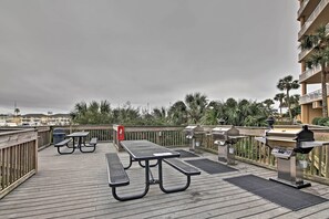A covered outdoor deck with picnic tables and barbecue grills. - Beachfront Destin Condo w/ Pool & Harbor View! (Destin)