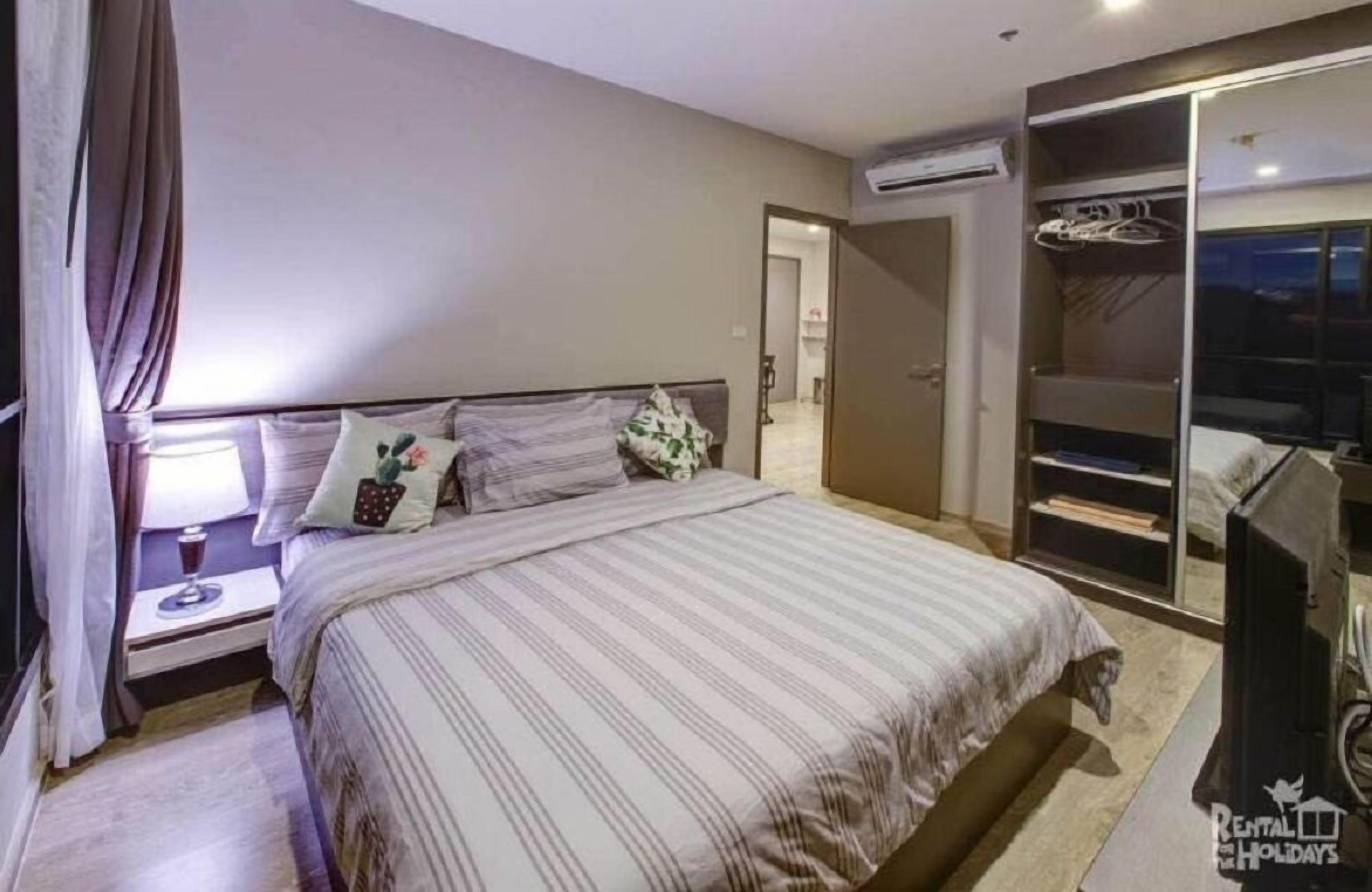 A bedroom with a bed, nightstand, and a walk-in closet.