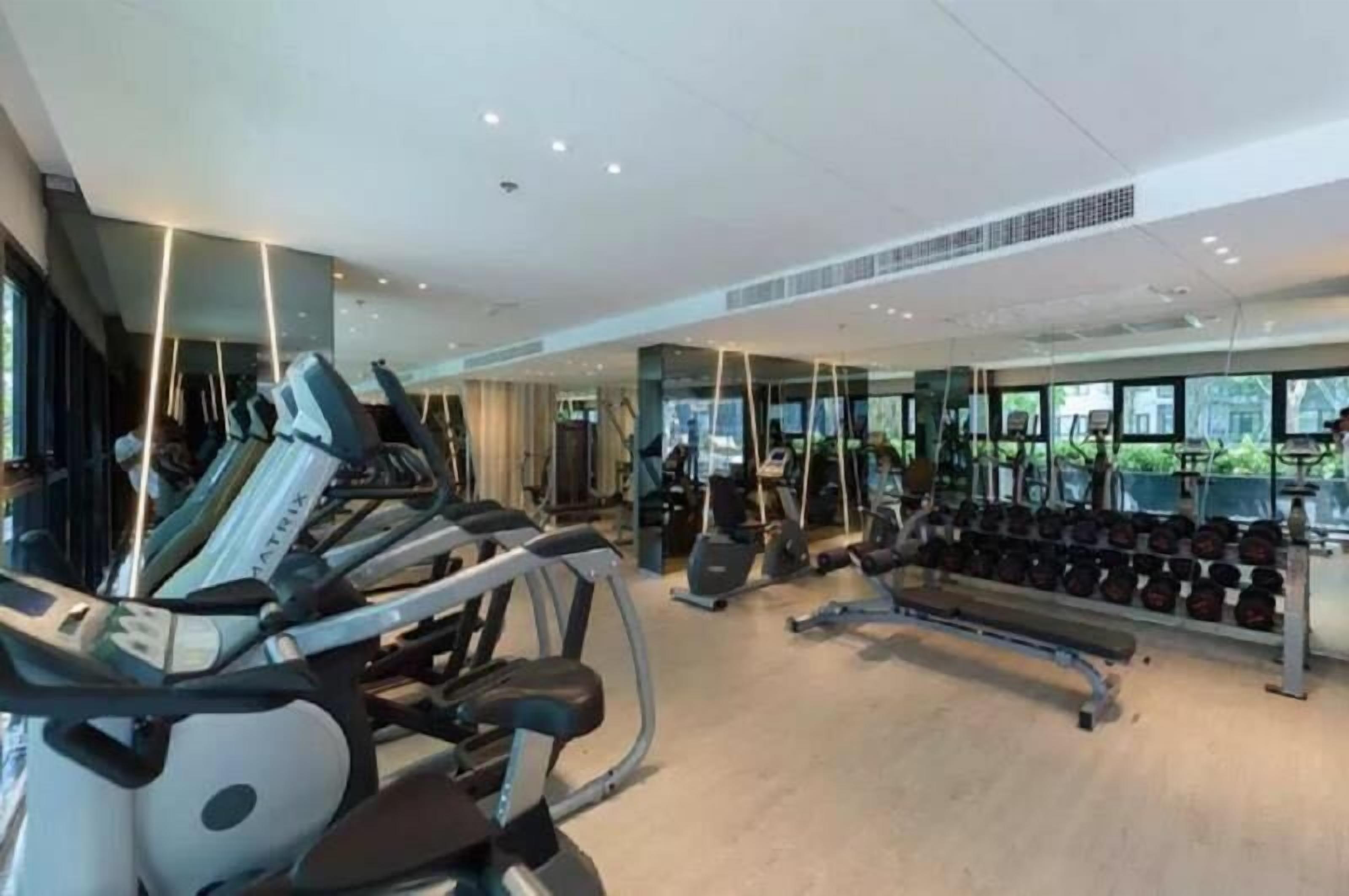 A modern gym with treadmills, dumbbells, and exercise equipment.