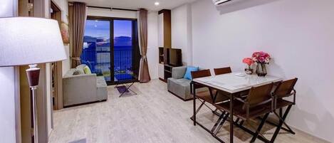 Una sala moderna con una mesa de comedor, sofás y un balcón con vistas.