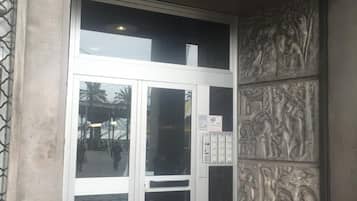A building entrance with a glass door and a metal gate.