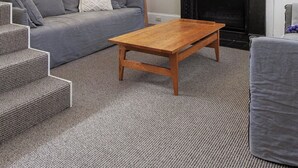 Una sala de estar con sofá, mesa de centro, chimenea, un cuadro y una lámpara.