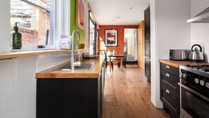 Una cocina con fregadero, estufa y comedor.