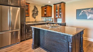 A modern kitchen with dark wood cabinets, stainless steel appliances, and a granite island. - Hiawassee Getaway w/ Deck, Mountain & Lake Views! (Hiawassee)