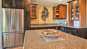 A kitchen with dark wooden cabinets, stainless steel appliances, and a granite countertop. - Hiawassee Getaway w/ Deck, Mountain & Lake Views! (Hiawassee)