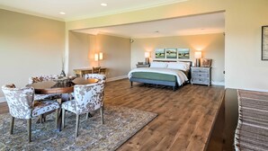 A bedroom with a bed, bedside tables, a desk with chairs, and a rug. - Hiawassee Getaway w/ Deck, Mountain & Lake Views! (Hiawassee)