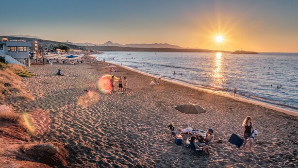 A beach with umbrellas, sun loungers, and a lifeguard tower. - Villa Elise, Beautiful house, A/C, Private Pool, Table Tennis . (Kokkini Hani, Heraklion, Crete)