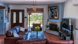 A living room with a sofa, a coffee table, a TV, and a fireplace. - Villa Elise, Beautiful house, A/C, Private Pool, Table Tennis . (Kokkini Hani, Heraklion, Crete)
