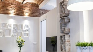 Un interior moderno con techo de ladrillo visto, paredes blancas y una mesa de comedor de madera.
