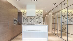 A modern kitchen with wooden cabinets, a central island, and a decorative backsplash. - Beautiful apartment in the centre of Madrid (Madrid)