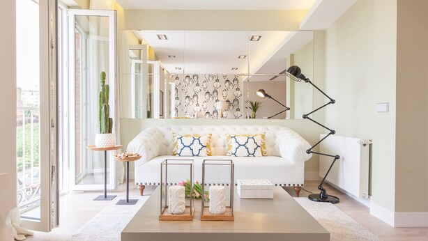 A modern living room with a white sofa, a coffee table with decorative items, and a floor lamp. - Beautiful apartment in the centre of Madrid (Madrid)
