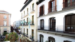 A multi-story building with balconies, a sign indicating a hostel, and a visible entrance. - Huertas studio - Apartment in the center of Madrid (Madrid)