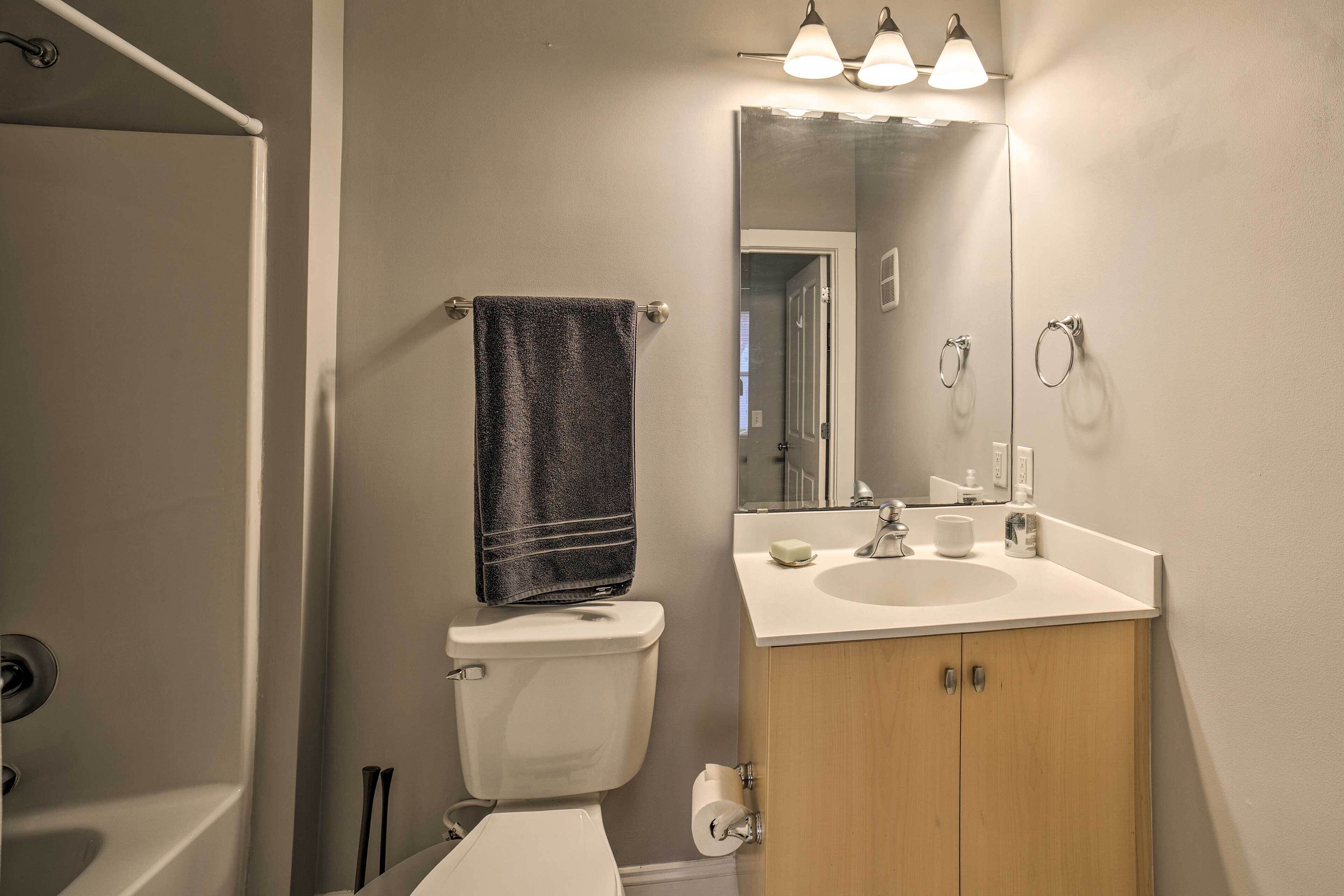 Une salle de bain équipée d’un WC, d’un lavabo, d’un miroir et d’un porte-serviettes.